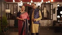 Portrait of Happy Indian Elderly Couple in Traditional Clothes Posing Together at Their Authentic Mumbai Home. Senior Husband and Wife Celebrating Diwali, Looking at the Camera. Slow Motion Zoom In