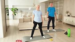 Fitness workout training. Senior adult mature healthy fit couple doing sports exercise on yoga mat on floor at home. Mid age old husband wife have training workout. Health care healthy lifestyle