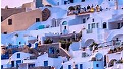 Timelapse of famous greek iconic selfie spot tourist destination Oia village with traditional white houses and windmills in Santorini island on sunset at night, Greece. Zoom out effect