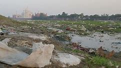 Heavily polluted river in front of the iconic Taj Mahal building in India