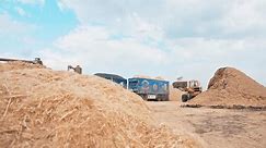 egypt - 04 20 2024: Wheel loader, with its large bucket in front, moves large amounts of linen at the field.