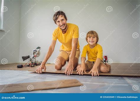 Father and Son Installing New Wooden Laminate Flooring on a Warm Film ...