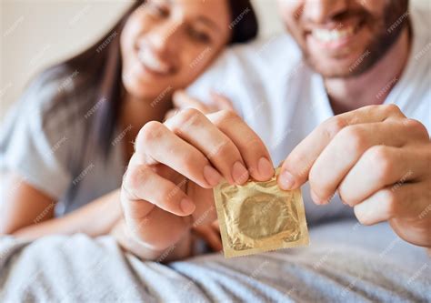 Premium Photo | Condom couple and sex with the hands of a man opening ...