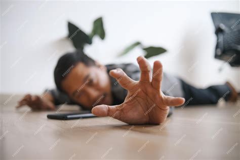 Premium Photo | Man falling and lying on the floor asking for help