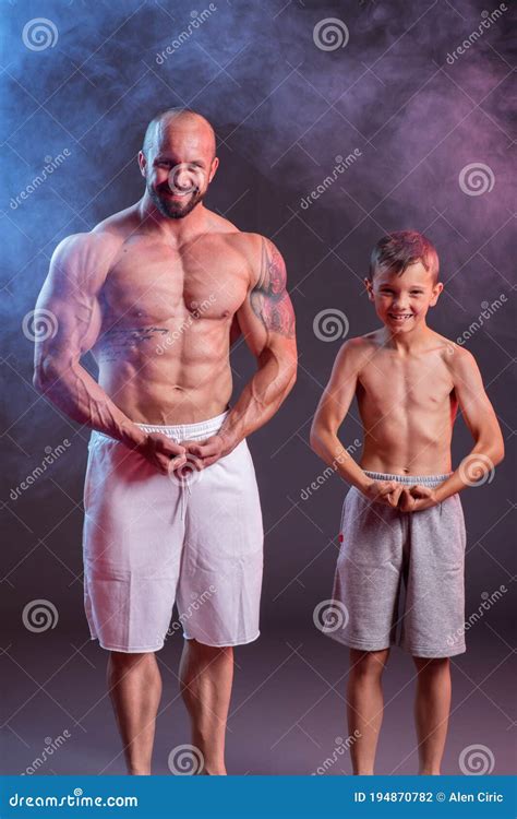 Powerful Muscular Man Shirtless Posing With His Son In The Studio With ...