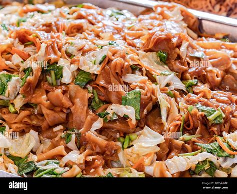 Fried, wide rice noodles and cabbage, cale and carrots at market in ...