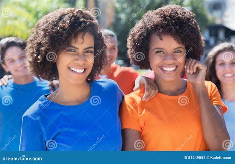 Two Laughing Latin Girlfriends with Group Stock Photo - Image of african, colorful: 81249552