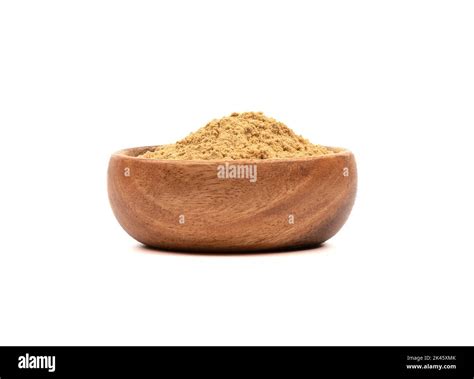 Powder of ground ginger root in a wooden bowl over white background ...