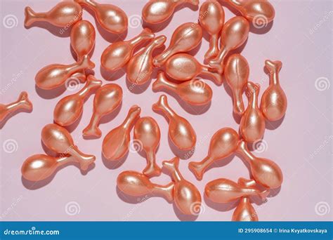 Capsules with a Cream or Serum for Face Treatment on Pink Background. Single Dose Capsules for ...