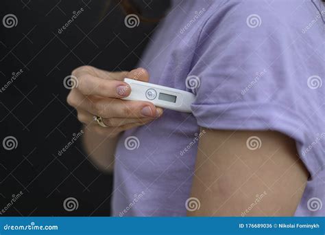 The Girl Measures the Temperature. she Holds a Thermometer Under Her Armpit. the Concept of Self ...
