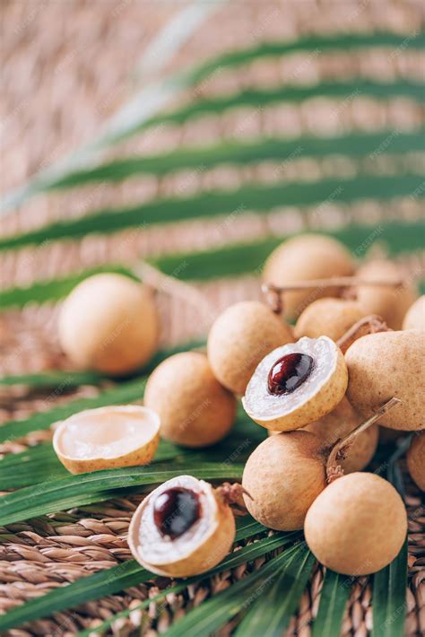 Premium Photo | Longan fruits over palm leaves on rattan background ...