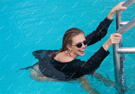 Premium Photo | Young woman relaxing in swimming pool on summer ...