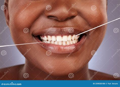 Floss for a Healthier Mouth. a Young Woman Flossing Her Teeth while Standing Against a Studio ...