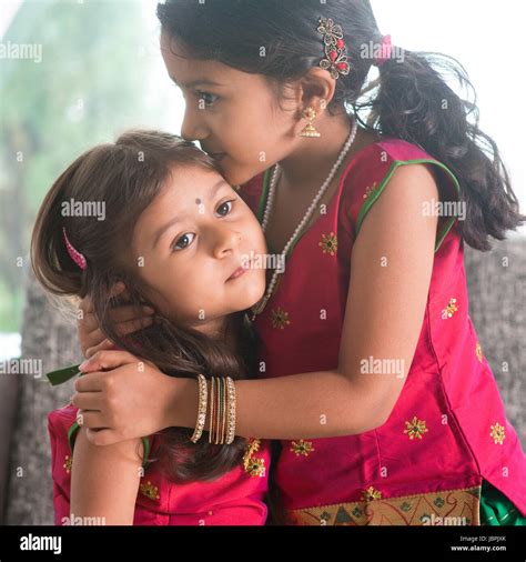Indian girl kissing her younger sister with love. Asian family at home ...
