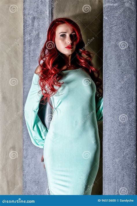 Beautiful Redhead Young Woman with Big Boobs in a Turquoise Dress on a Old Gray Wall Background ...