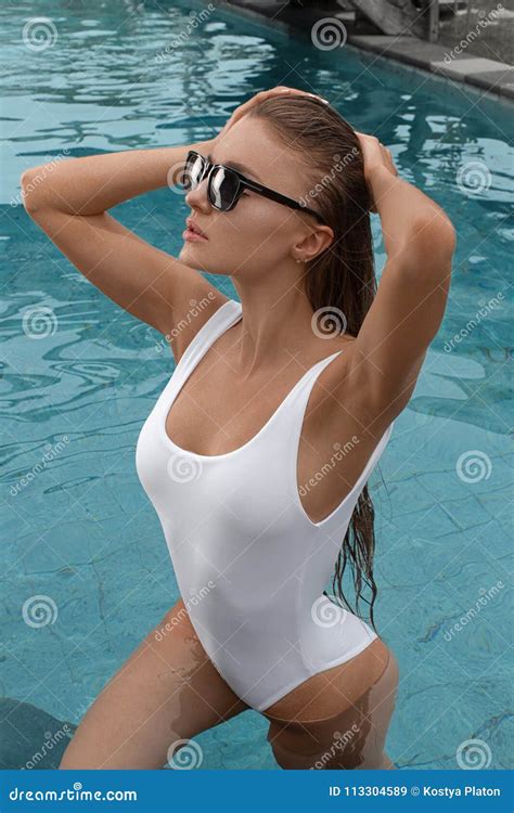 Beautiful Girl in a White Bathing Suit Enjoys Relaxing in the Pool ...