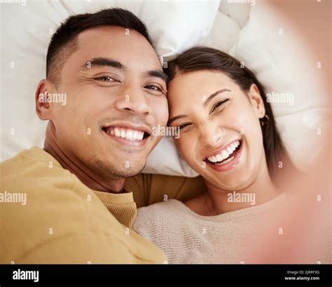 A happy and in love couple taking a selfie while smiling, laughing and ...