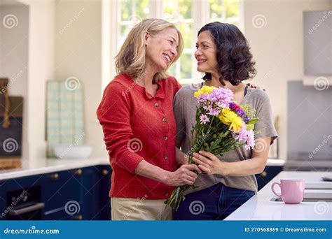 Loving Same Sex Mature Female Couple in Kitchen with Woman Giving ...