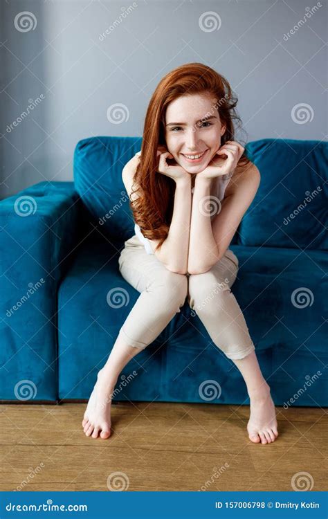 Redhead Woman Sitting on the Blue Couch at Home. Stock Photo - Image of ...