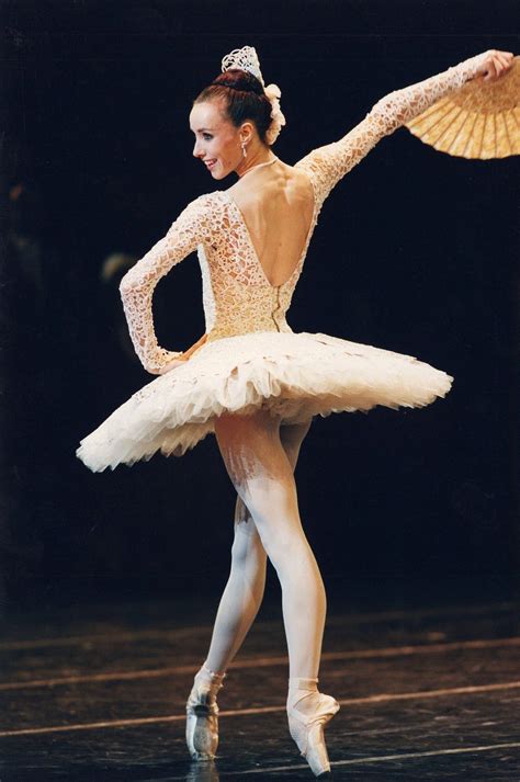 the ballerina is wearing a white tutu and holding a fan