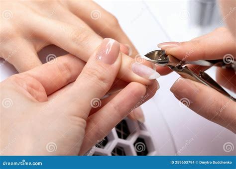A Manicurist Removes Cuticles during a Nail Extension Procedure in a ...