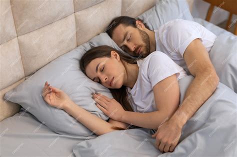 Peaceful couple sleeping together in cozy comfortable bed | Premium Photo