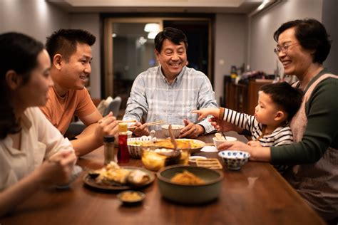 Chinese family having dinner around the dining room table - Asian Agribiz