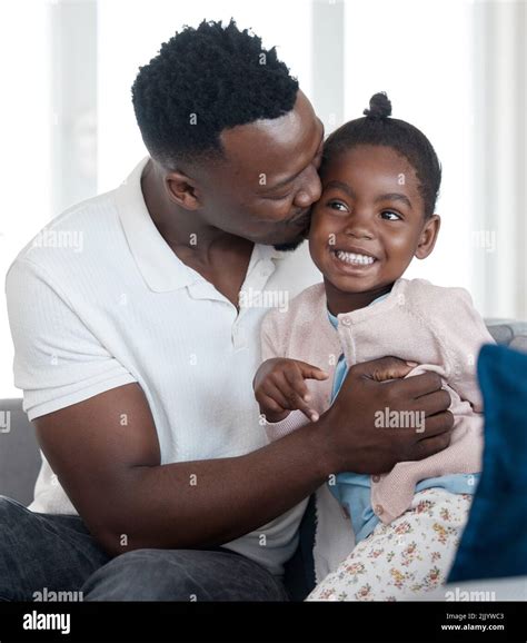 Daddy loves you. a handsome young man kissing his daughter on the cheek ...