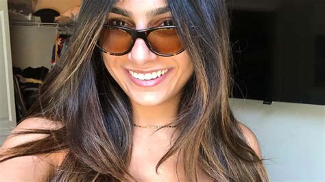 Download A Woman With Long Hair And Sunglasses Smiling | Wallpapers.com