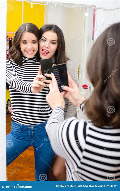 Two Teenage Girls Taking Selfie Pictures in Front of the Mirror Stock ...