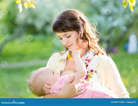 Young Mother Breast Feeding Her Baby Girl Outdoors Stock Photo - Image ...