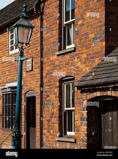 Red brick terraced houses and traditional street lamp on a street at the Black Country Living ...