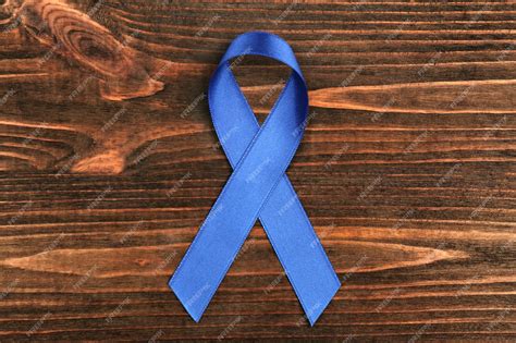 Premium Photo | Blue ribbon on wooden background colon cancer concept
