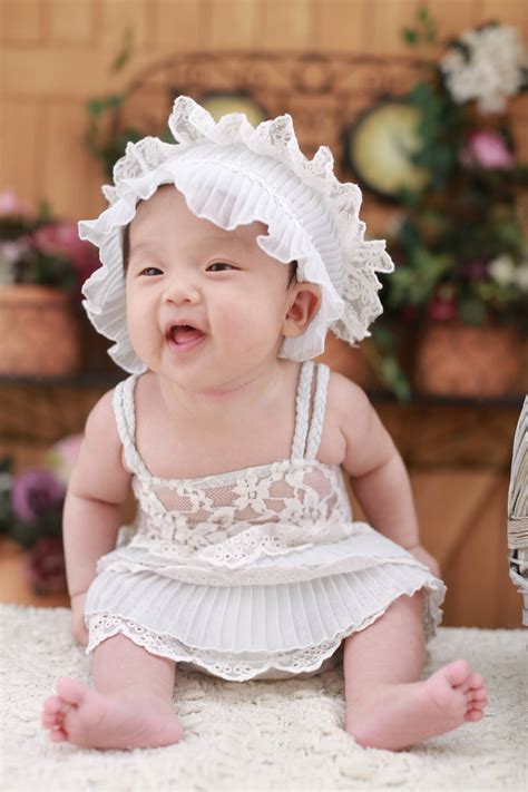 Download Cute Baby In White Dress And Hairband Wallpaper | Wallpapers.com