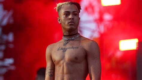 XXXTentacion Is Standing Without Shirt And Having Tattoos On Neck Chest And Hand In A Blur Red ...