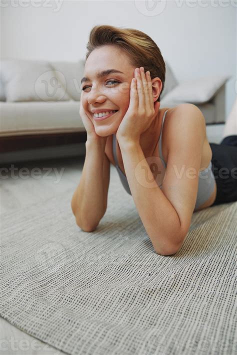 Teenage girl lying on the floor at home smiling in home clothes with a ...
