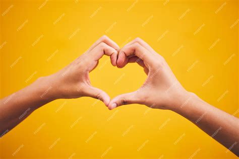 Premium Photo | Heart hands and person in studio with thank you message or gesture on orange ...