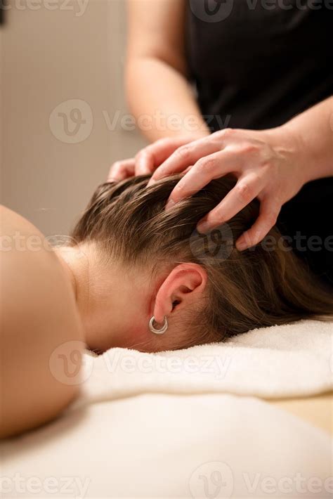 Head massage therapy with hands gently massaging the scalp of a relaxed ...