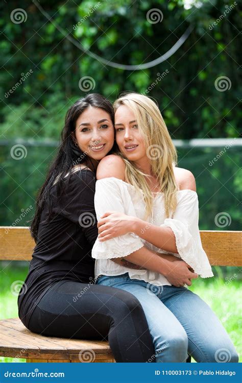 A Pair of Proud Lesbian in Outdoors Sitting on a Wooden Table, Brunette ...