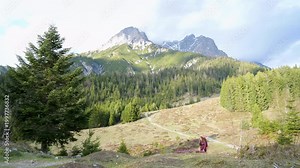 Blonde woman hiking through breathtaking alpine mountains under warm summer sunlight, capturing freedom, adventure, outdoor lifestyle and inspiring travel moments in untouched nature