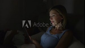 Middle Aged Couple In Bed With Woman Using Tablet Computer