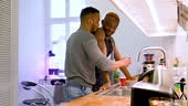 Two gay men relaxing in the kitchen at home and enjoying each others...