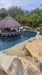 1.2K views · 3K reactions | Hands down, one of our most insane builds ever. This backyard features a Tiki Hut outdoor kitchen and swim-up bar, an oversized pool, a huge infinity-edge spa, grottos, upon grottos, upon grottos, with a secret dry cave behind them, and lush tropical landscaping. Pure paradise. #insanepools #lucaslagoons | Lucas Lagoons Design | Facebook