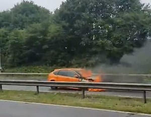 Orange-coloured Ford car on fire on M42