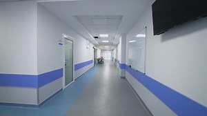 Empty Corridor In Modern Hospital. Long corridor in hospital with doors and reflections