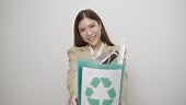 Electronic waste management. Beautiful Asian woman puts electronic...