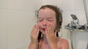 a little girl washes in the shower, soap got into her eyes