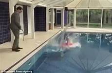pool pushed swimming her woman down being filmed bending placing quickly stand again going hand before behind gives