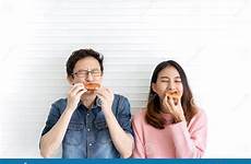 hungry asian eating face food tasty attractive expression facial pizza smile fast couple wall background preview