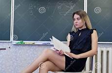 legs teacher strict chair blonde young her sits crossing lady preview